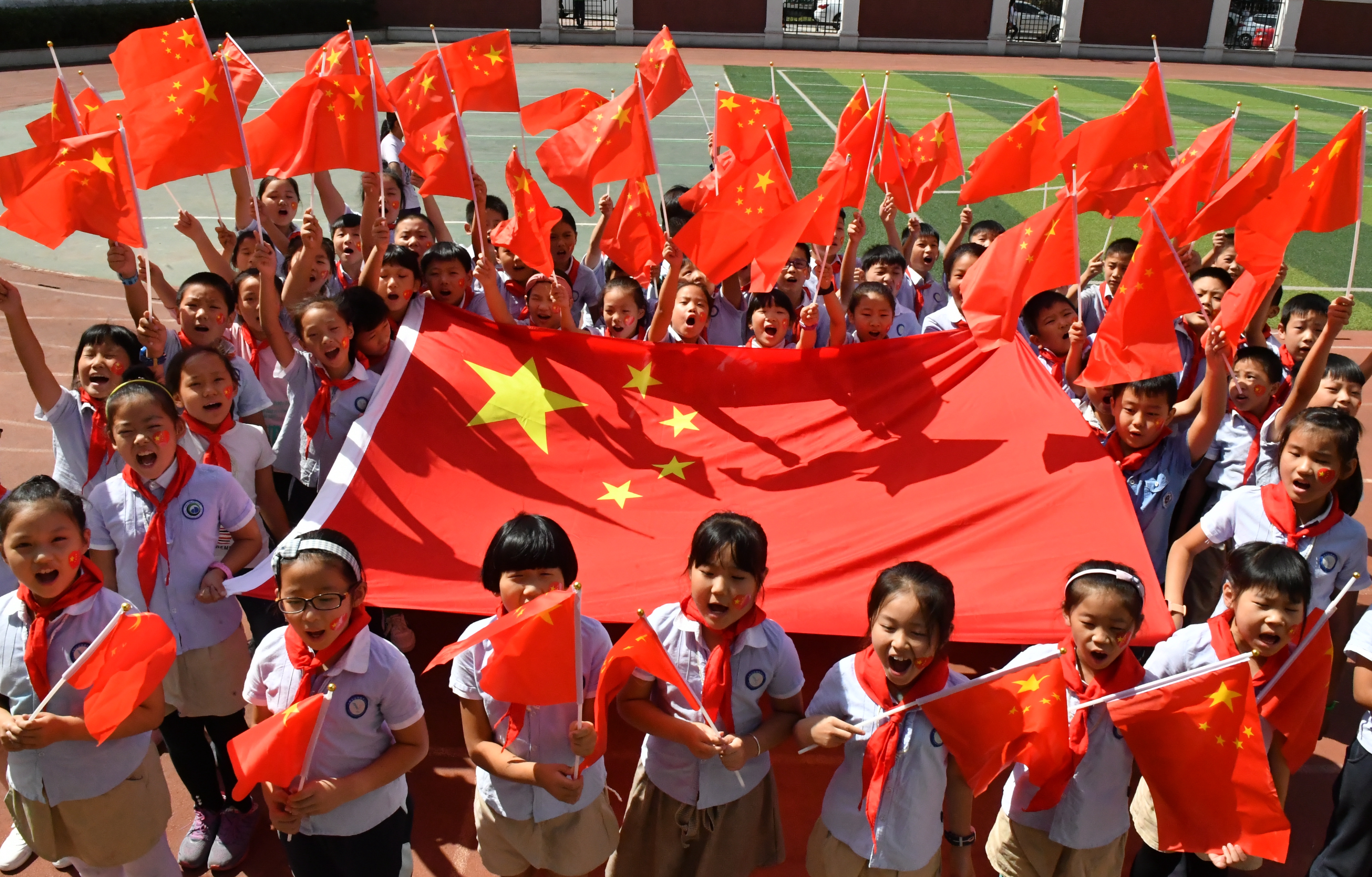 敬礼 "主题中队会,少先队员们通过齐唱国歌,学习国旗知识,与国旗合影