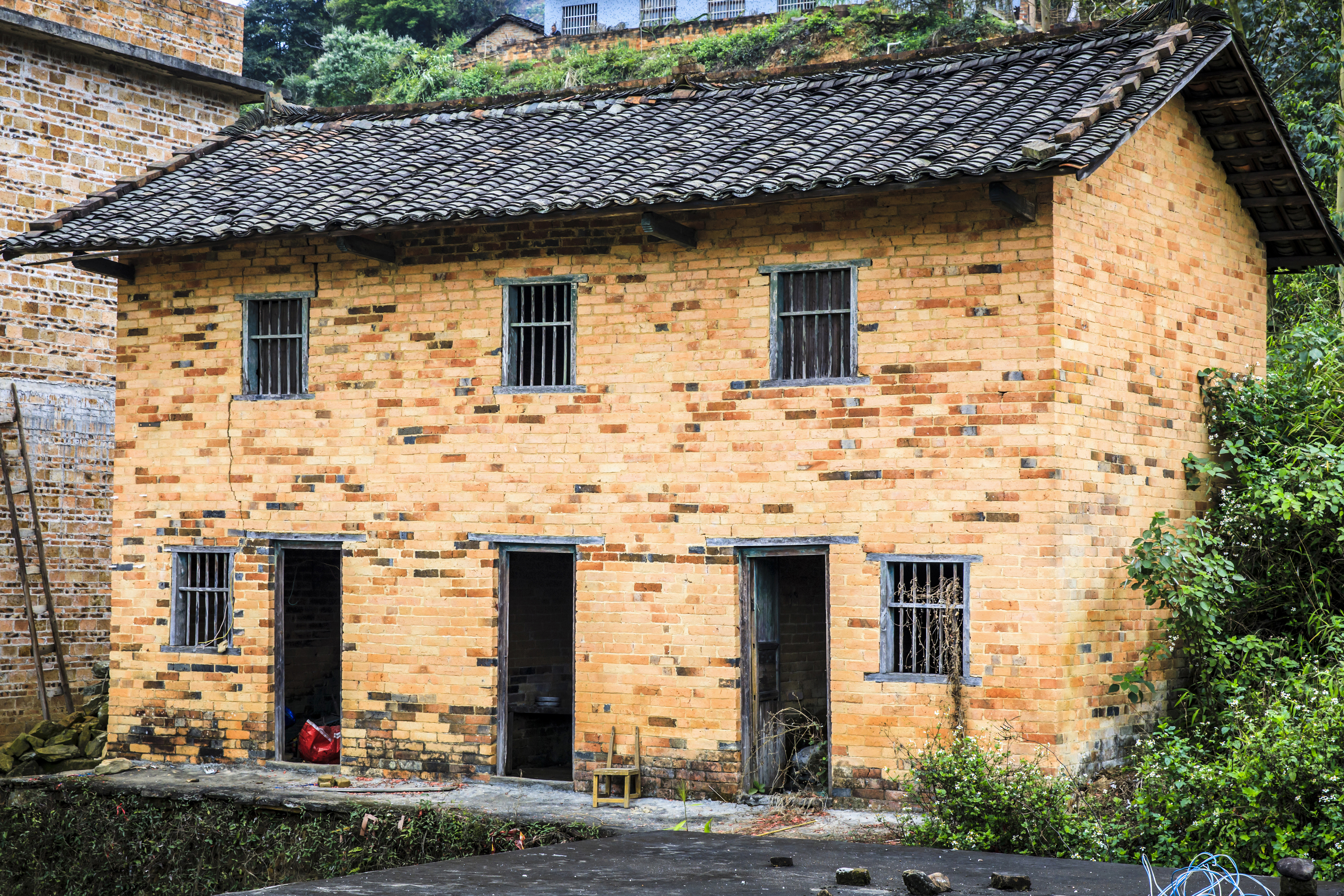 《喜气临门》组照5:李兴华早年自制泥砖依山建起的旧瓦房,已经是上雨